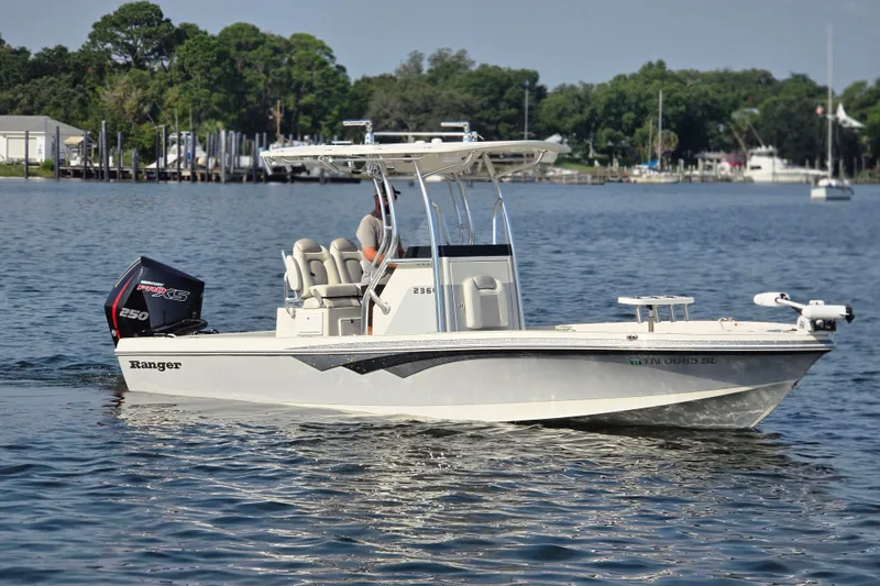 The Image of 2019 Ranger 2360 Bay Ranger boat cruising on a calm lake with scenic background. - 0