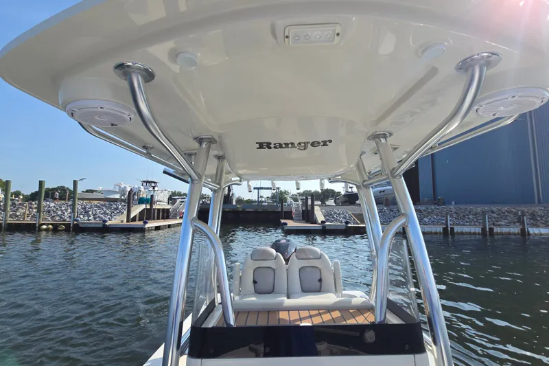 Slide: The Image of 2019 Ranger 2360 Bay Ranger boat docked, featuring T-top and seating, in a marina setting. - 26