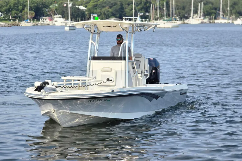 Slide: The Image of 2019 Ranger 2360 Bay Ranger boat cruising on a calm lake with scenic background. - 3