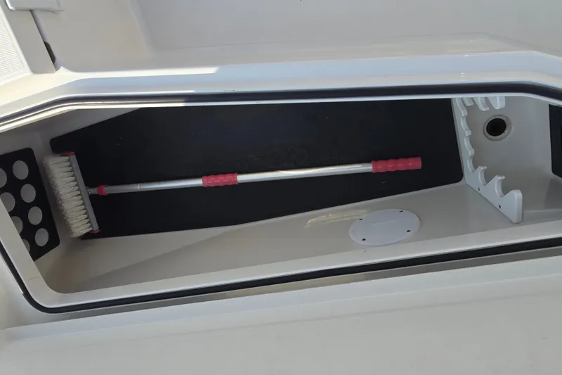 Slide: The Image of Storage compartment of a 2019 Ranger 2360 Bay Ranger boat with a brush inside. - 23