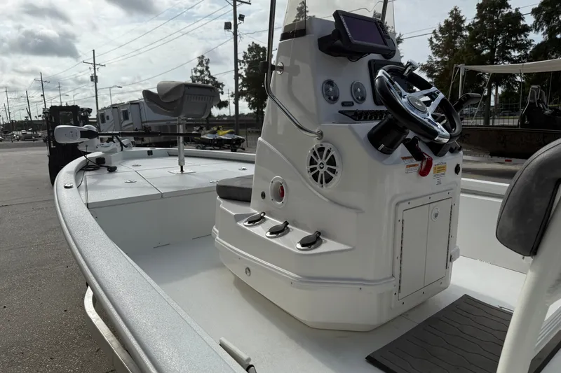 Slide: The Image of 2023 Avid 19 FS boat with steering console and seating, parked outdoors. - 10