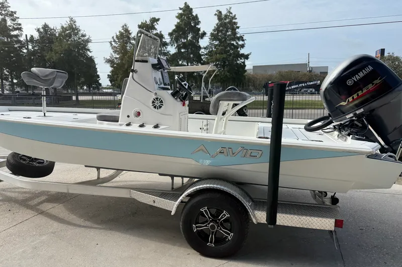 Slide: The Image of 2023 Avid 19 FS boat with Yamaha engine on trailer, parked outdoors. - 7