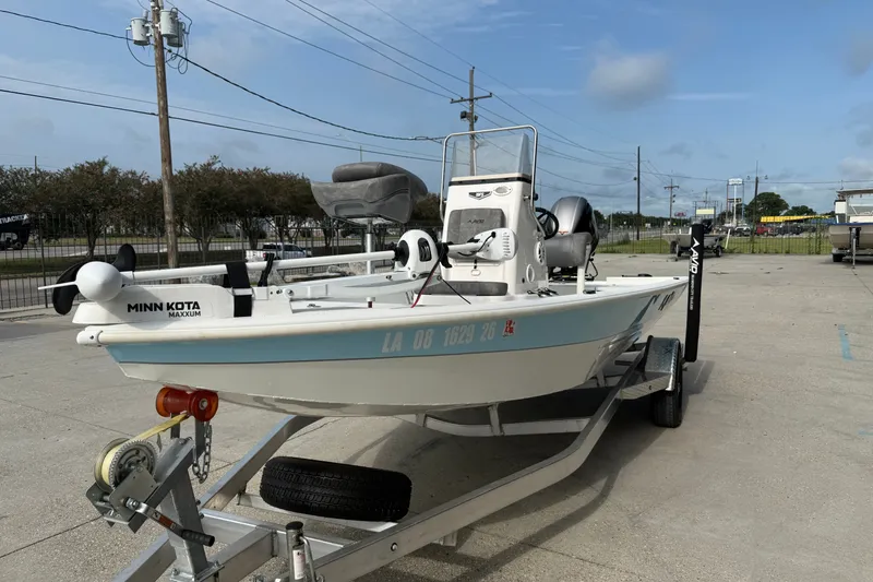 Slide: The Image of 2023 Avid 19 FS boat on trailer with Minn Kota Maxxum motor, parked outdoors. - 5