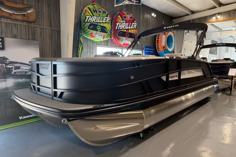 The Image of 2027 Evotti 521QL pontoon boat displayed indoors with vibrant water sports gear. - 1