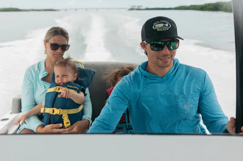 Slide: The Image of Family enjoying a ride on a 2027 Sea Hunt BX25FS boat, cruising through open waters. - 34