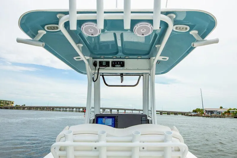 Slide: The Image of Manufacturer Provided Image: 2026 Sea Hunt BX 25 FS boat console with electronics, speakers, and blue canopy on water. - 14