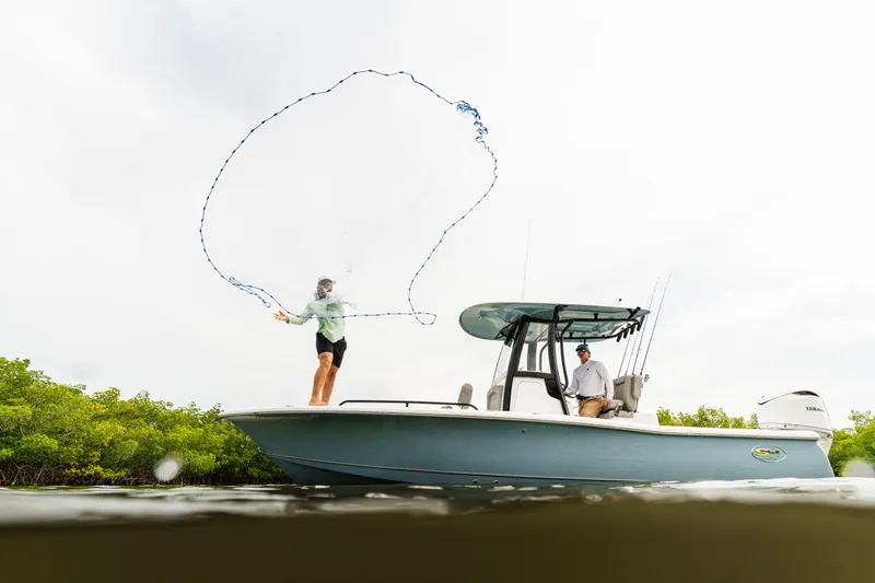Slide: The Image of Two people fishing on a 2027 Sea Hunt BX25FS boat in shallow waters. - 6