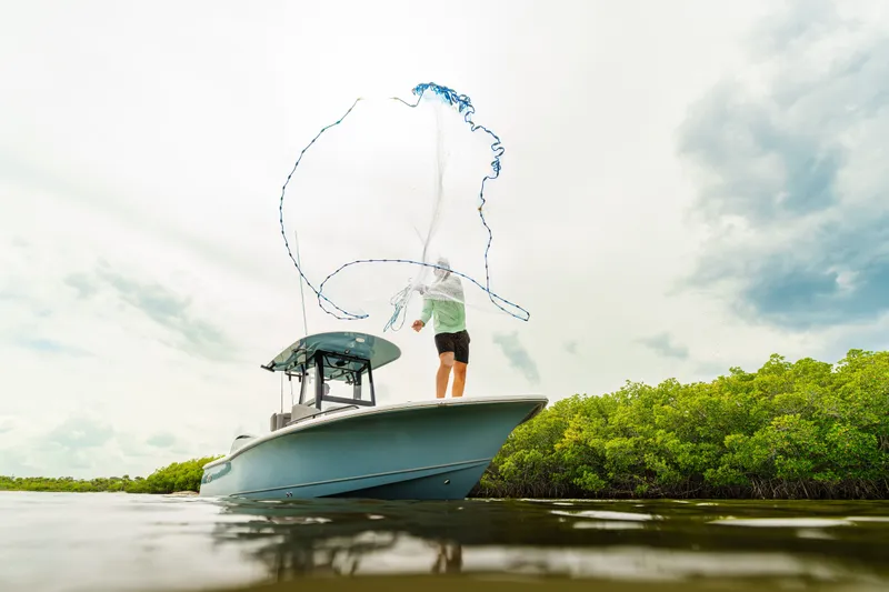 Slide: The Image of Person casting net from Sea Hunt BX25FS boat, 2027 model, in scenic waters. - 19