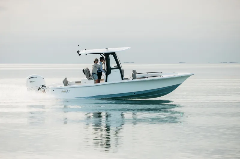 Slide: The Image of 2027 Sea Hunt BX25FS boat cruising on calm water with passengers. - 49