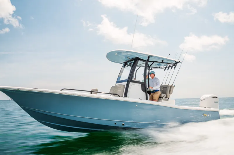 Slide: The Image of 2027 Sea Hunt BX25FS boat cruising on open water under clear skies. - 11