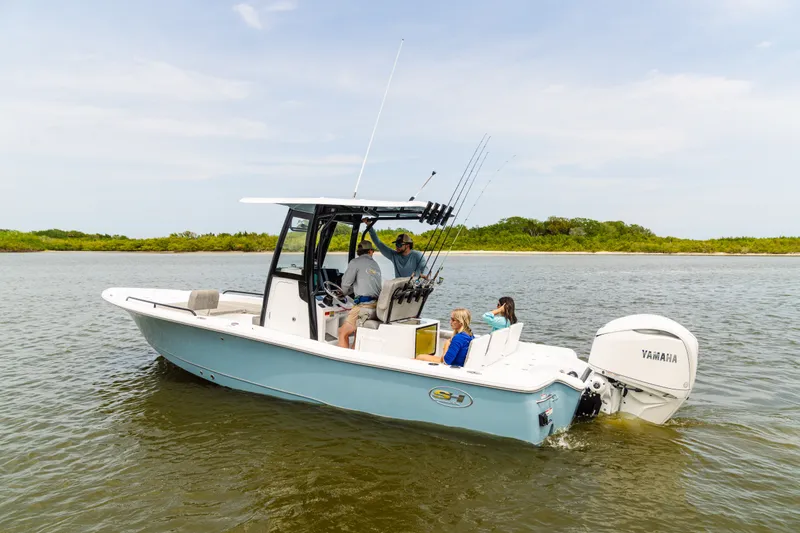 Slide: The Image of 2027 Sea Hunt BX25FS boat cruising on calm water with passengers onboard. - 23