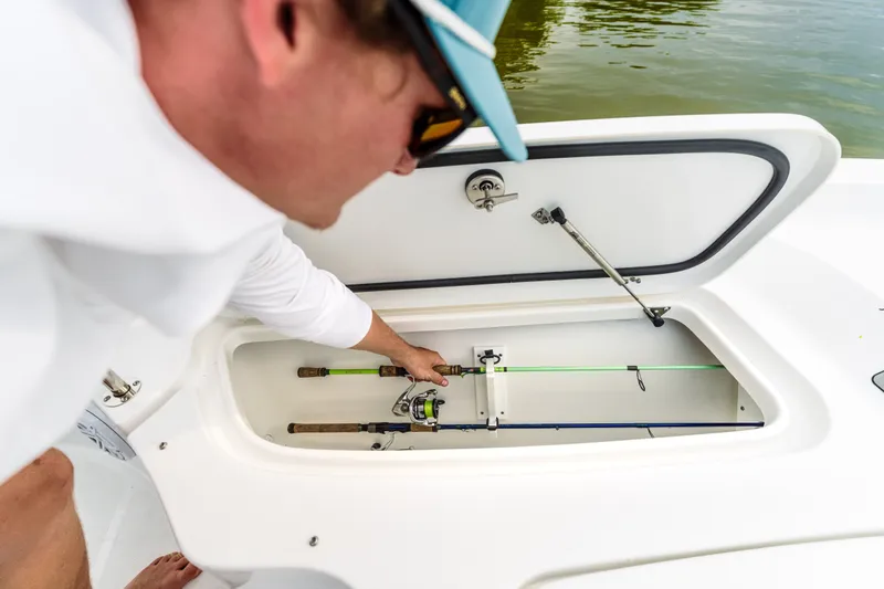 Slide: The Image of Man accessing fishing rod storage on 2027 Sea Hunt BX25FS boat. - 15