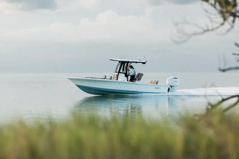 Slide: The Image of 2027 Sea Hunt BX25FS boat cruising on calm water under cloudy sky. - 5
