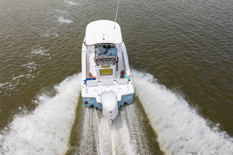 Slide: The Image of 2027 Sea Hunt BX25FS boat cruising on open water, rear view. - 28
