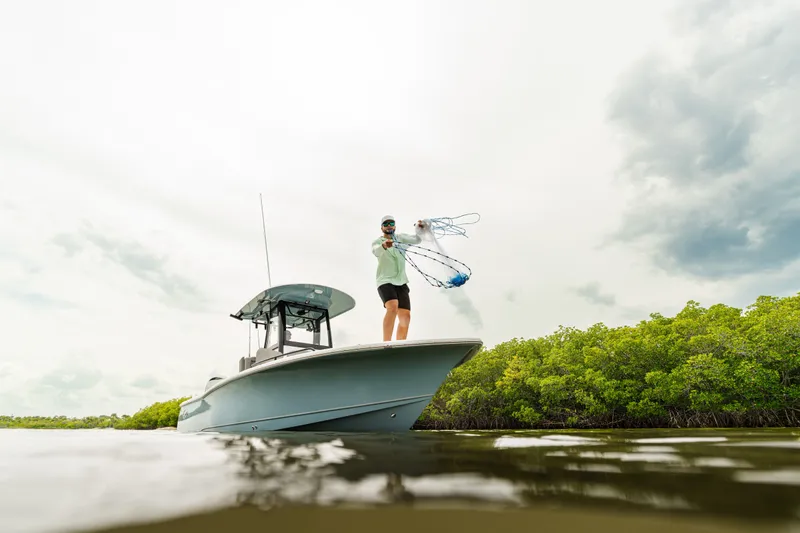 Slide: The Image of Man casting net from 2027 Sea Hunt BX25FS boat in mangrove waters. - 20