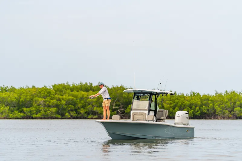 Slide: The Image of Man fishing on a 2027 Sea Hunt BX25FS boat in calm waters. - 17