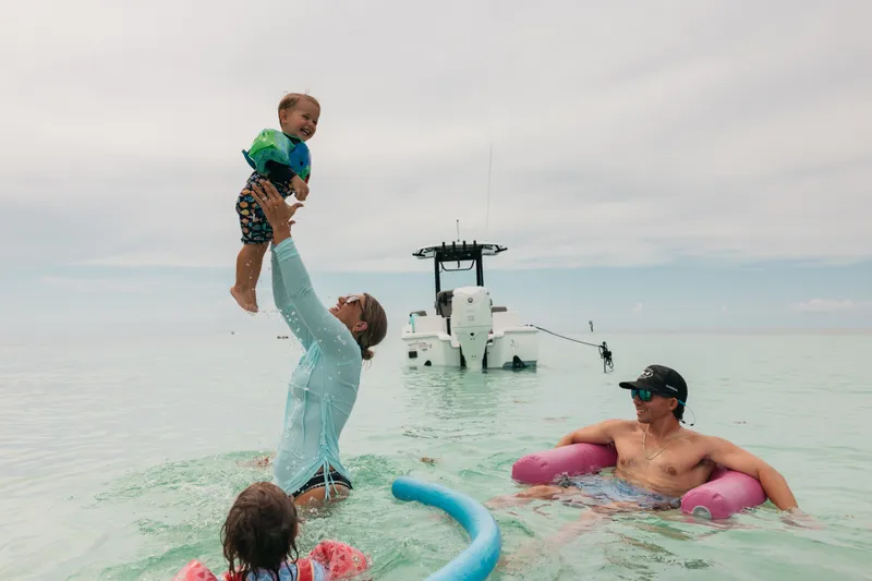 Slide: The Image of Family enjoying a day at sea with a 2027 Sea Hunt BX25FS boat in the background. - 38