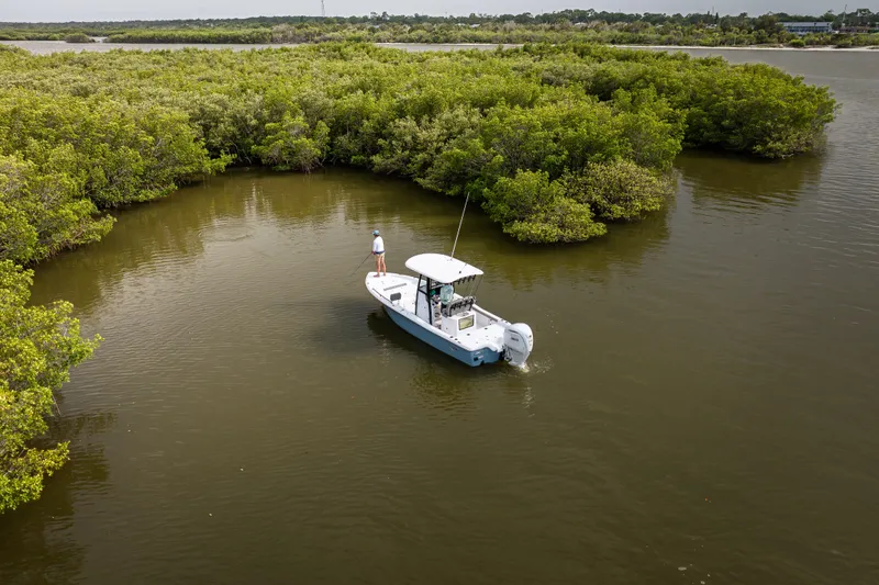Slide: The Image of 2027 Sea Hunt BX25FS boat navigating through lush mangroves in calm waters. - 27