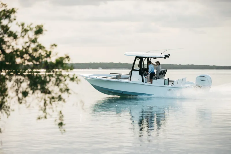 Slide: The Image of 2027 Sea Hunt BX25FS boat cruising on calm water with two people onboard. - 43