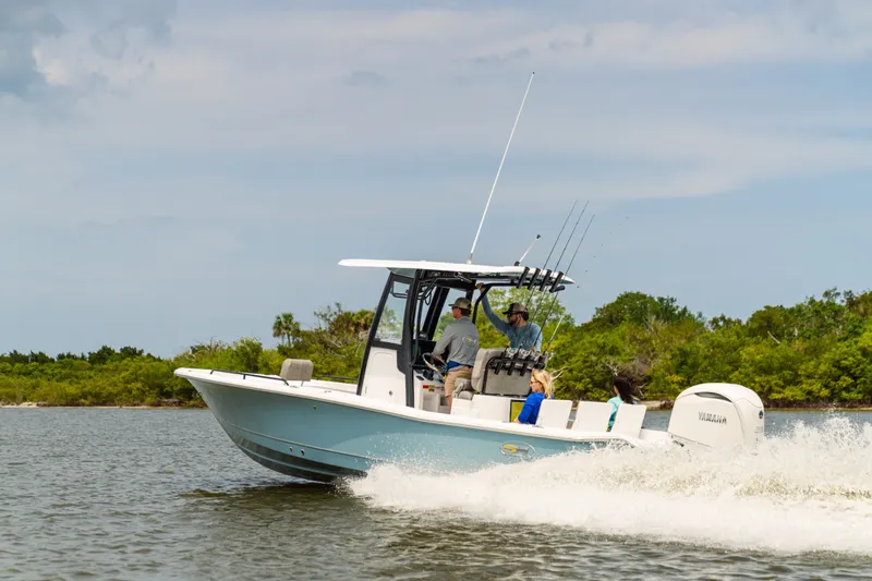 Slide: The Image of 2027 Sea Hunt BX25FS boat cruising on a calm waterway with passengers onboard. - 22