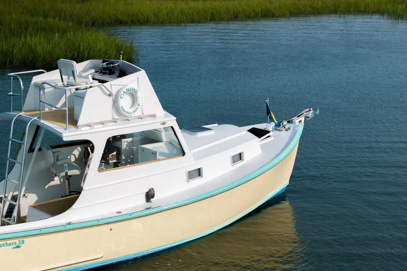 Slide: The Image of 1958 Albury Brothers boat on calm water, featuring a sleek white and turquoise design. - 23