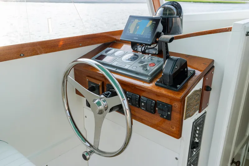 Slide: The Image of 1958 Albury Brothers boat helm with wooden dashboard and modern navigation equipment. - 56