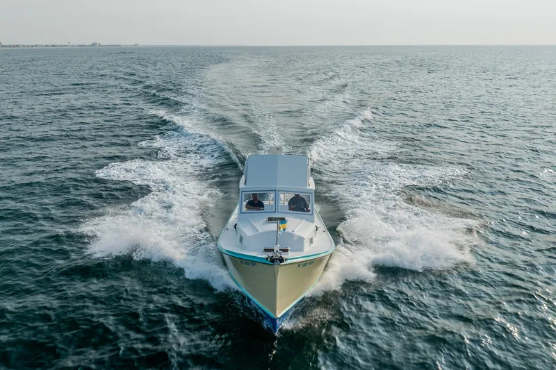 Slide: The Image of Vintage 1958 Albury Brothers boat cruising on open water, creating a dynamic wake. - 33