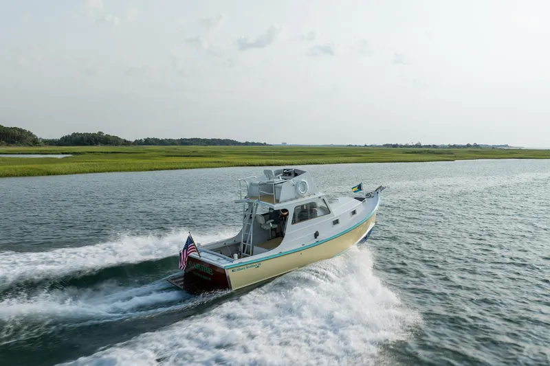 Slide: The Image of Vintage 1958 Albury Brothers boat cruising on a scenic waterway. - 25