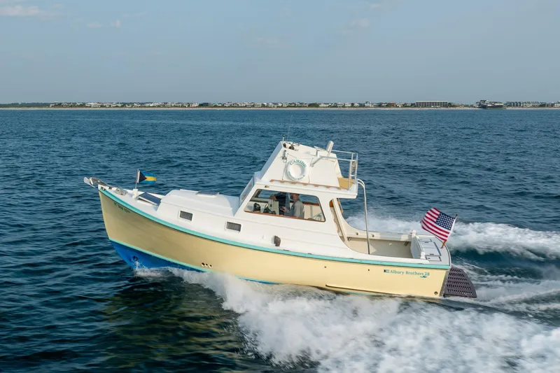 Slide: The Image of 1958 Albury Brothers boat cruising on open water with American flag. - 35