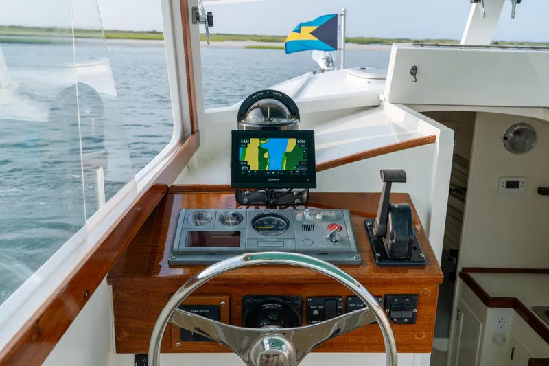 Slide: The Image of 1958 Albury Brothers boat helm with navigation system and Bahamian flag in the background. - 59