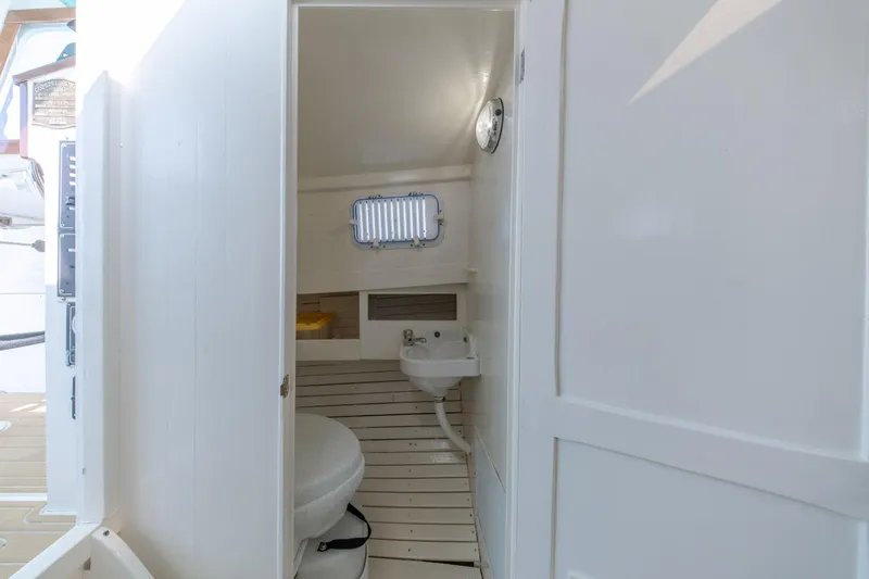 Slide: The Image of Interior of a 1958 Albury Brothers boat featuring a compact bathroom with a toilet and sink. - 79