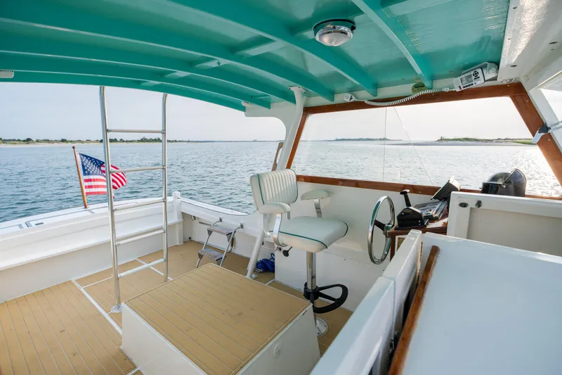 Slide: The Image of Interior of a 1958 Albury Brothers boat with American flag, turquoise ceiling, and steering wheel. - 65