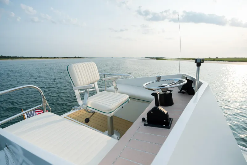 Slide: The Image of 1958 Albury Brothers boat helm with steering wheel and seat on calm water. - 88