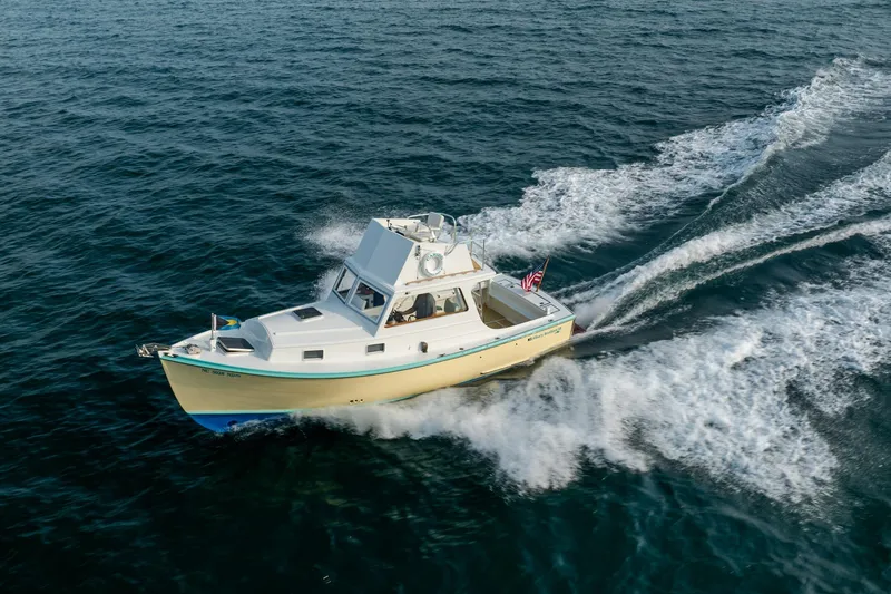 Slide: The Image of 1958 Albury Brothers boat cruising on open water, creating a wake. - 34