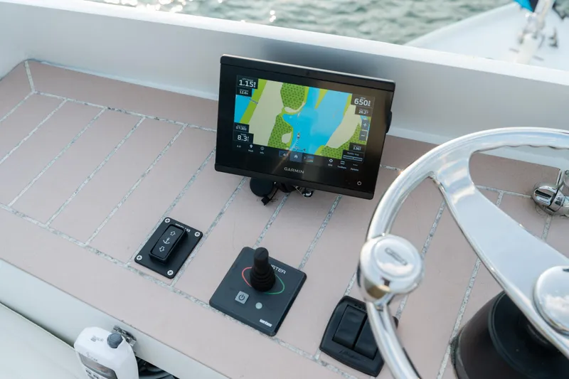 Slide: The Image of 1958 Albury Brothers boat dashboard with Garmin navigation system and steering wheel. - 86
