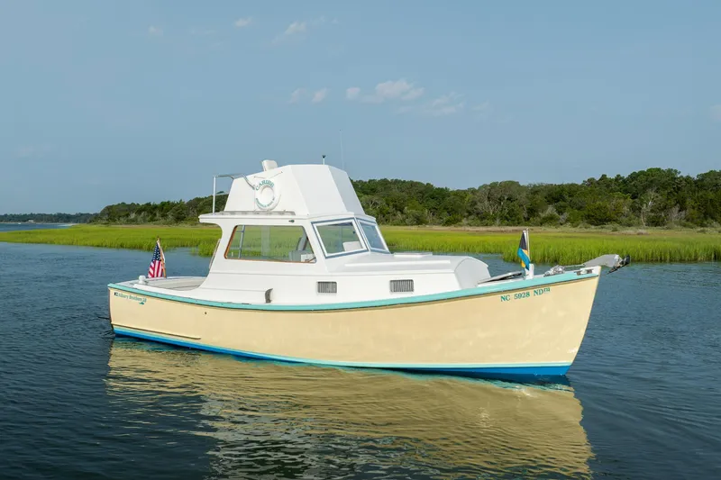 Slide: The Image of Vintage 1958 Albury Brothers boat cruising on calm water near lush shoreline. - 16