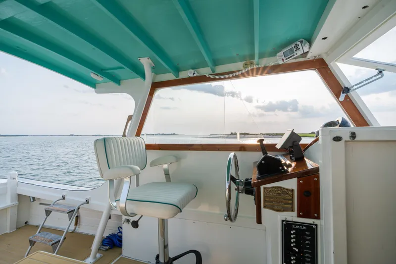 Slide: The Image of 1958 Albury Brothers boat interior with turquoise accents and steering wheel, overlooking calm waters. - 62