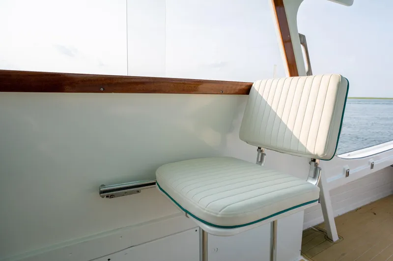 Slide: The Image of 1958 Albury Brothers boat with white cushioned seat and wooden trim, overlooking calm water. - 72