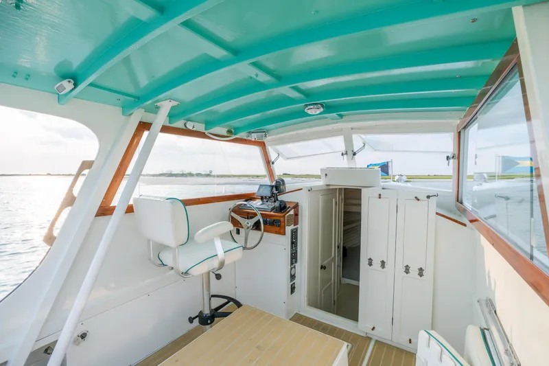 Slide: The Image of Interior of a 1958 Albury Brothers boat with turquoise ceiling and white seating. - 54