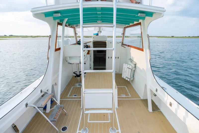Slide: The Image of 1958 Albury Brothers boat interior with ladder, wooden deck, and open water view. - 64