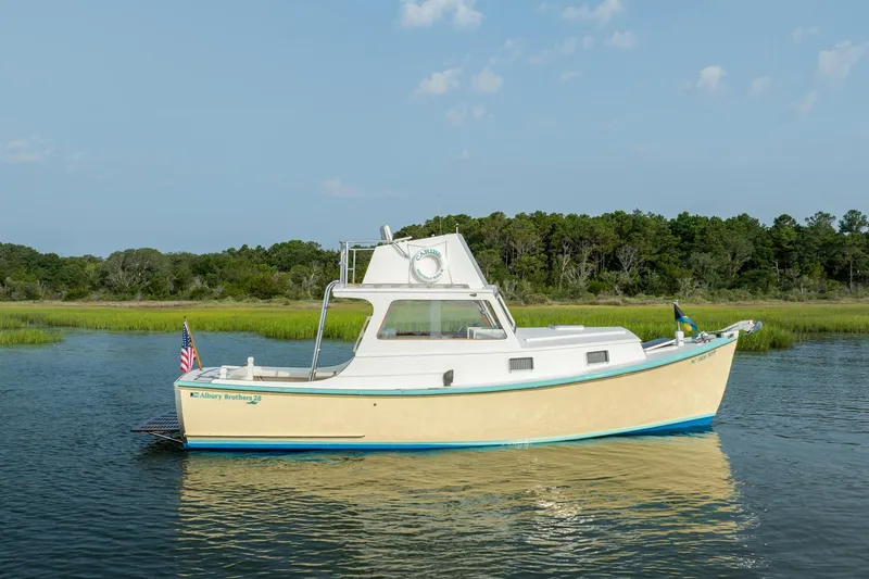 Slide: The Image of Vintage 1958 Albury Brothers boat on serene water with lush green background. - 17