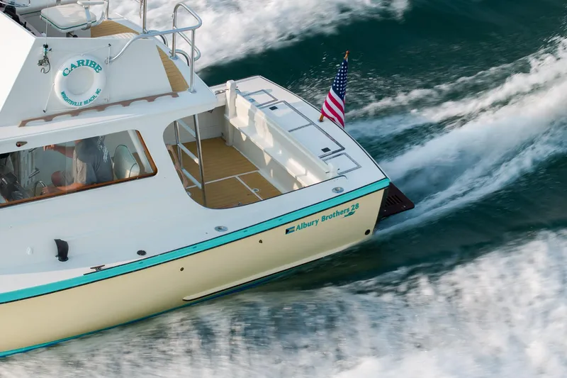 Slide: The Image of 1958 Albury Brothers boat cruising on water with American flag. - 47