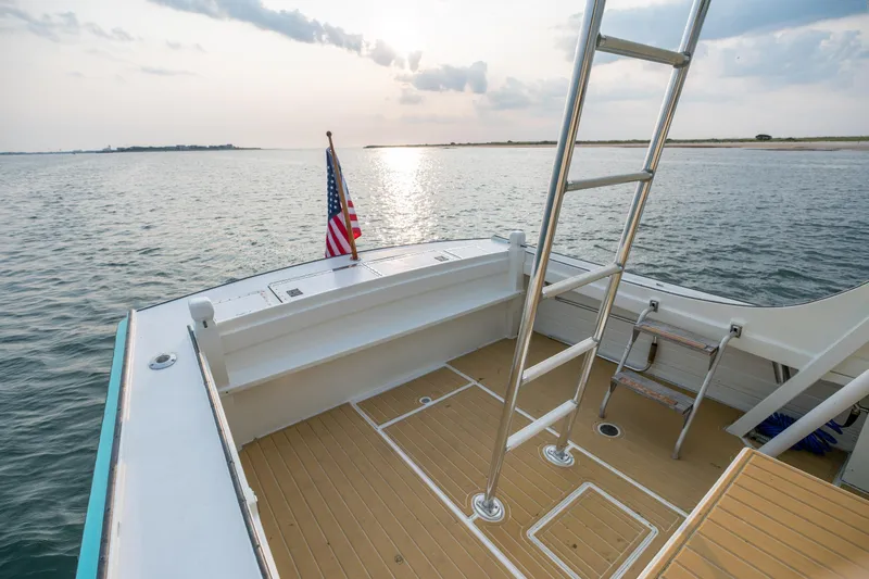 Slide: The Image of Vintage 1958 Albury Brothers boat deck with American flag, ladder, and serene ocean view. - 50