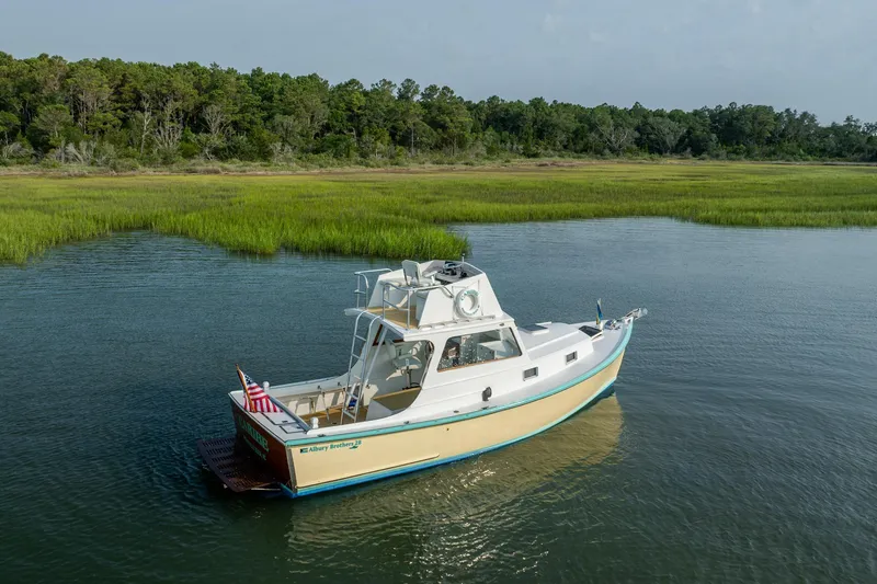 Slide: The Image of 1958 Albury Brothers boat on serene water, surrounded by lush greenery. - 20