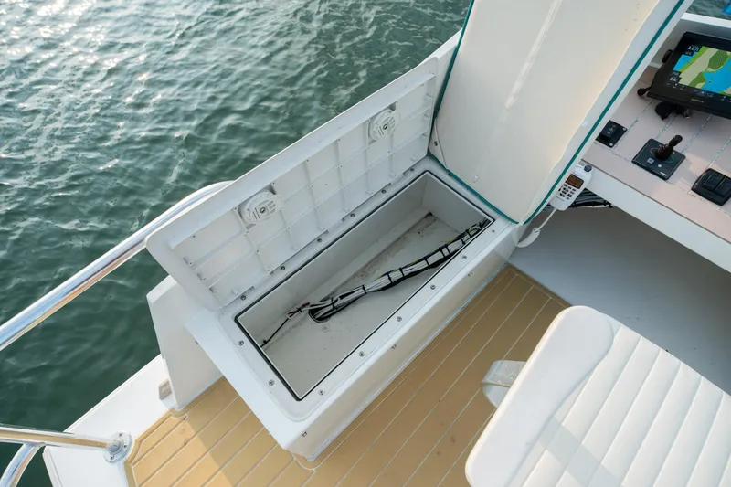 Slide: The Image of 1958 Albury Brothers boat with open storage compartment and control panel by the water. - 90