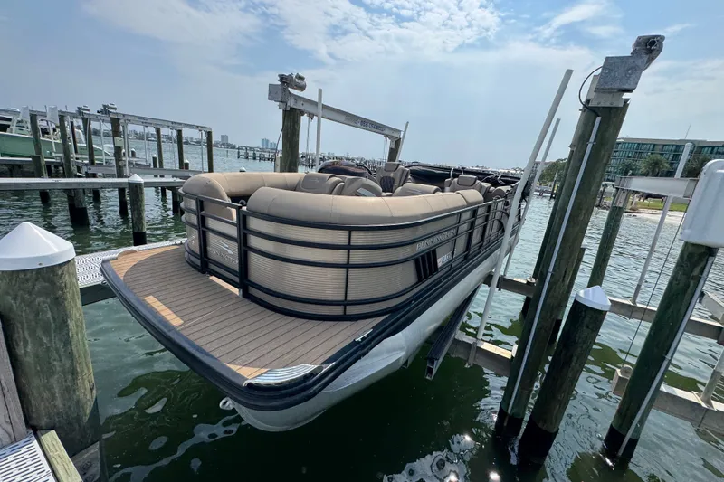 Slide: The Image of 2022 Bennington 23 LXFB pontoon boat docked at marina under clear sky. - 7