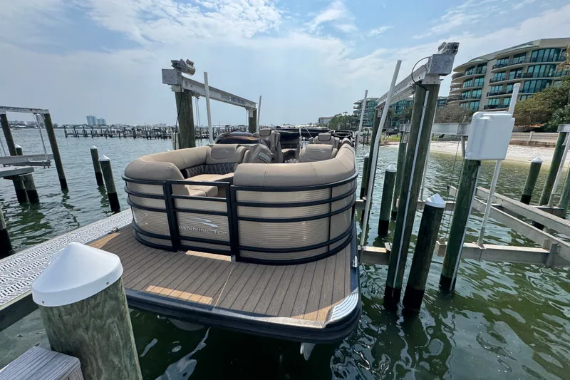 Slide: The Image of 2022 Bennington 23 LXFB pontoon boat docked at marina under clear sky. - 6