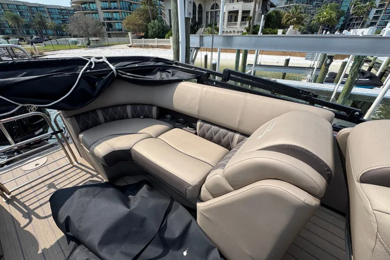 Slide: The Image of Luxurious seating on 2022 Bennington 23 LXFB boat, docked near waterfront buildings. - 22