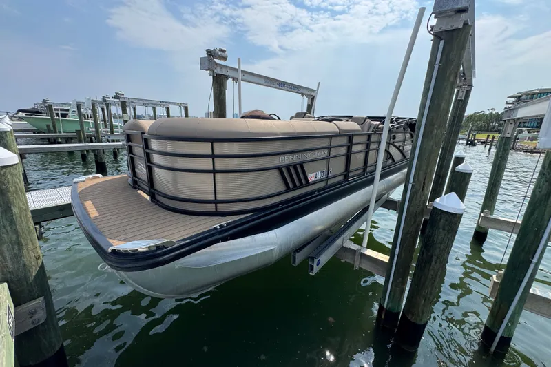 Slide: The Image of 2022 Bennington 23 LXFB pontoon boat docked at a marina on a sunny day. - 8