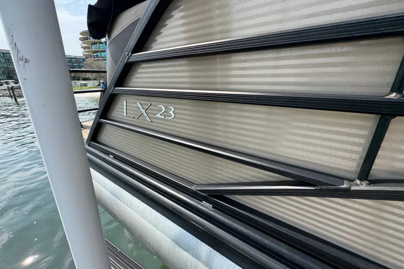 Slide: The Image of 2022 Bennington 23 LXFB pontoon boat docked by the water. - 9